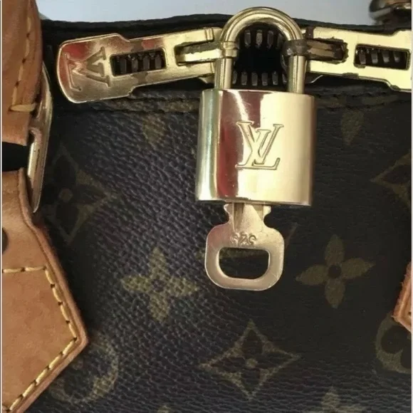 NEAR MINT Louis Vuitton lock and key set.